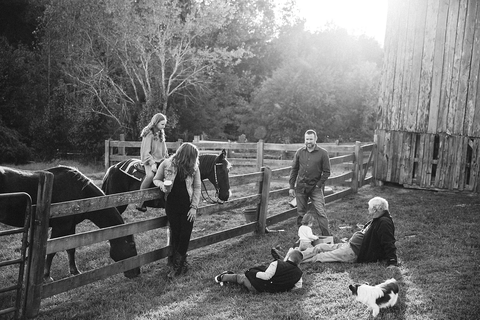 Family gathered with the horses beside the old barn